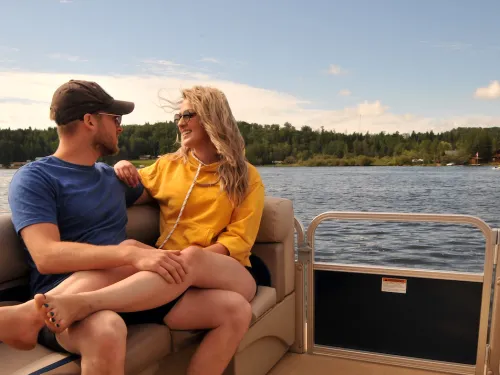 A couple cozy up on a boat on the lake in Athabasca