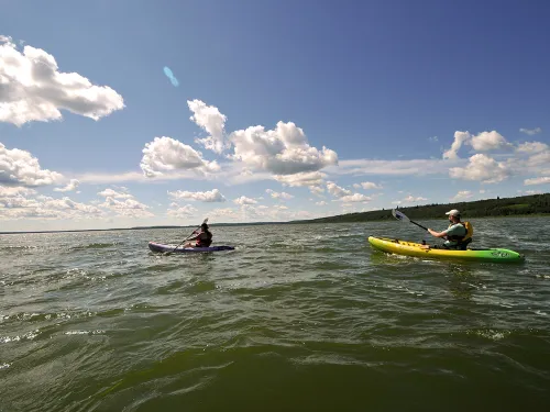 A family kayaks on the lake in MD Bonnyville