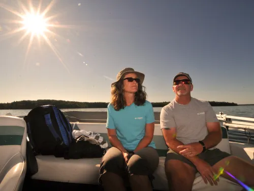 A couple in the sun on a boat in Cold Lake