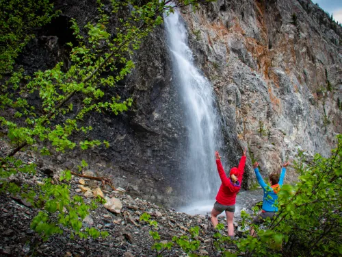 A wide shot of two people enjoying a waterfall in Alberta