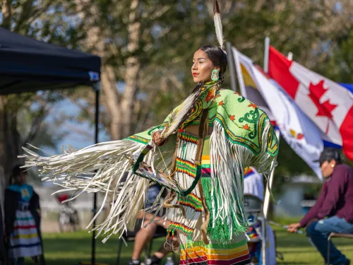 Indigenous dancer in front of Canadian Flag