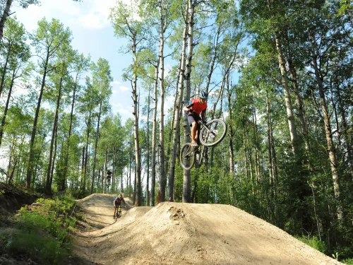 Riders taking air at the Whitecourt Bike Park, Whitecourt, AB.