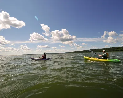 A family kayaks on the lake in MD Bonnyville