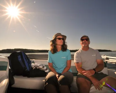 A couple in the sun on a boat in Cold Lake