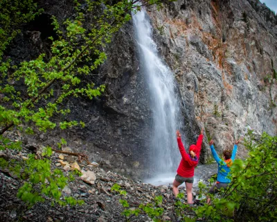 A wide shot of two people enjoying a waterfall in Alberta