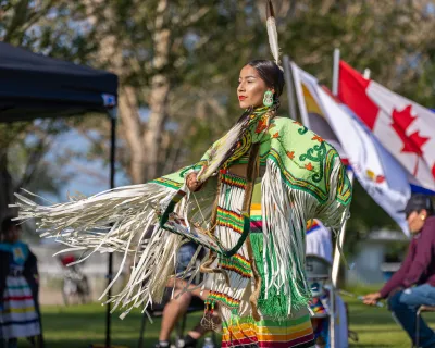 Indigenous dancer in front of Canadian Flag