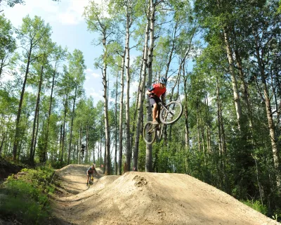 Riders taking air at the Whitecourt Bike Park, Whitecourt, AB.