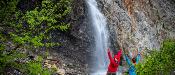 A wide shot of two people enjoying a waterfall in Alberta