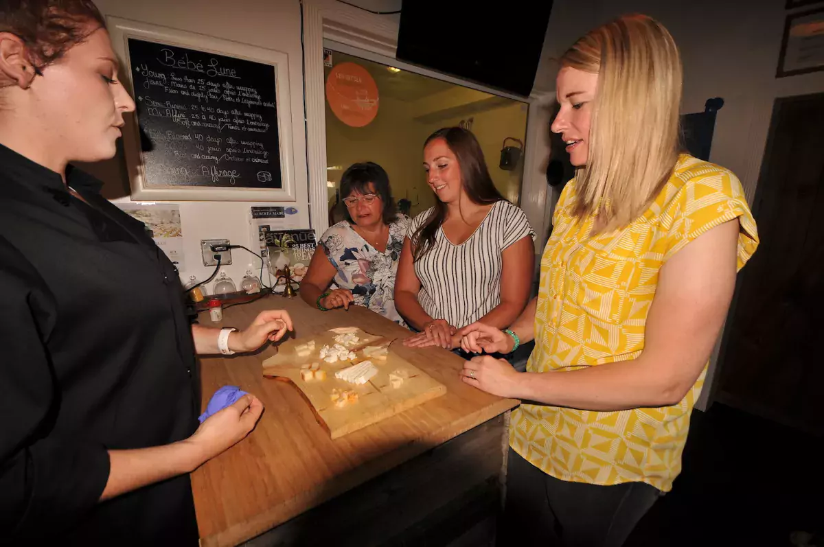 Three women eat cheese and other food in Vermilion