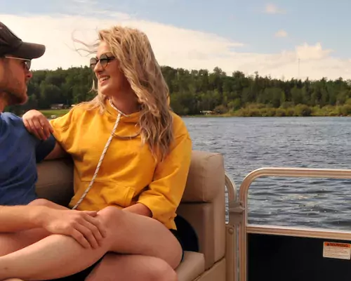 A couple cozy up on a boat on the lake in Athabasca