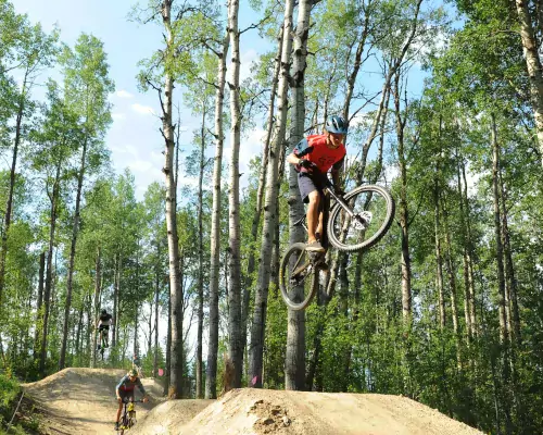 Riders taking air at the Whitecourt Bike Park, Whitecourt, AB.